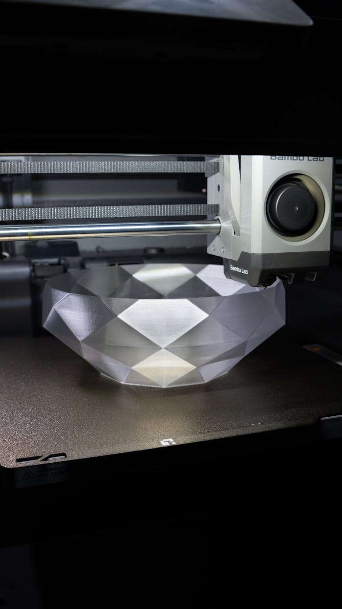 why-choose-us-02 A 3D printer creating a geometric crystal-like bowl in a modern setup.